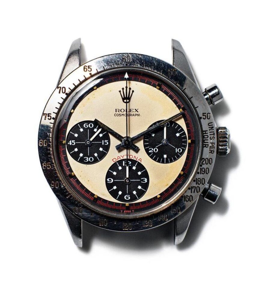 Most Expensive Rolex Watches close-up of Paul Newman’s Rolex Cosmograph Daytona Ref. 6239 with a cream dial, black subdials, and tachymeter bezel on a white background.
