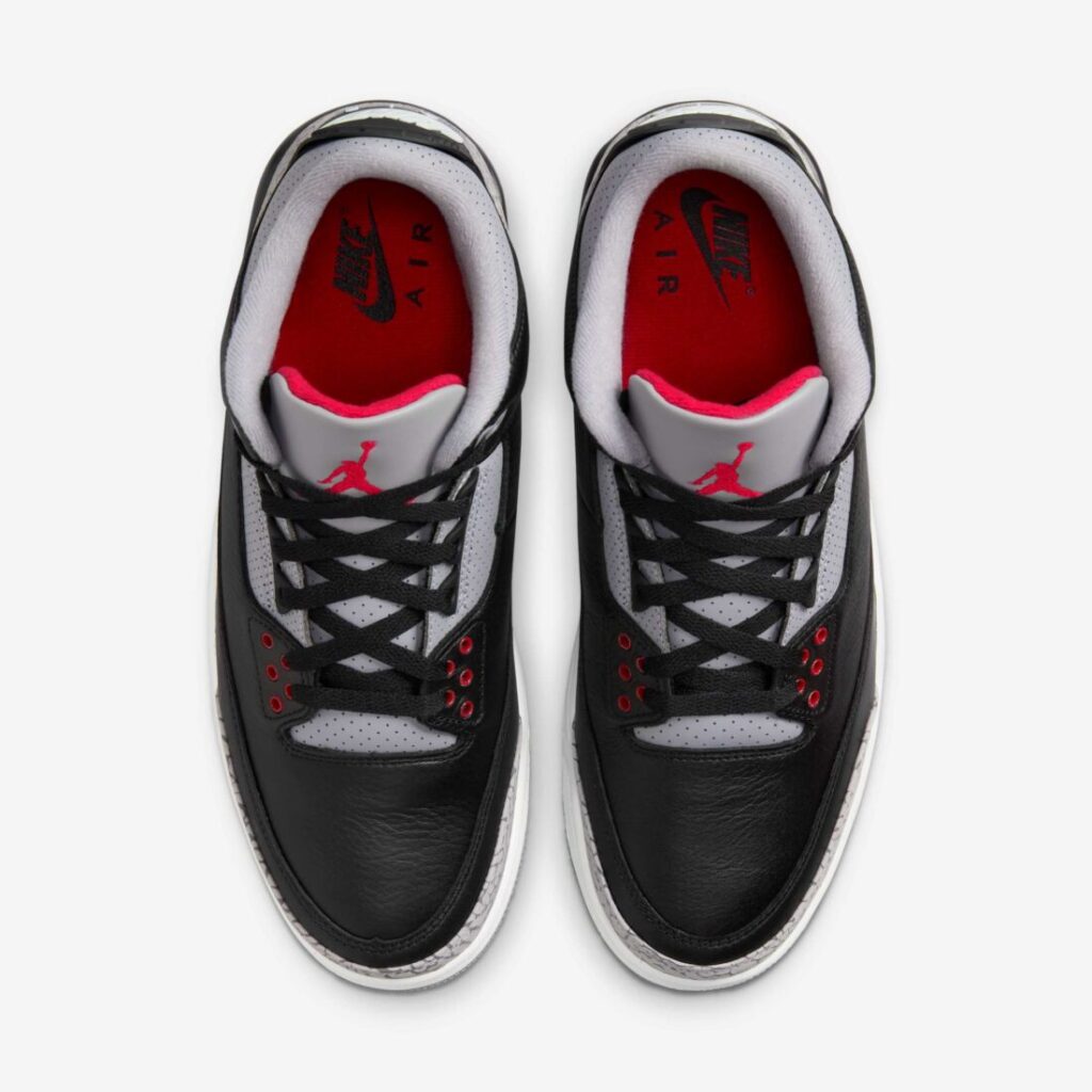 Top-down view of the Air Jordan 3 Retro Black Cement pair showing black leather uppers, grey perforated tongues, red eyelets, and red insoles on a white background